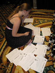 Adrienne sitting on the floor surrounded by beer judging sheets, trying to make a choice
