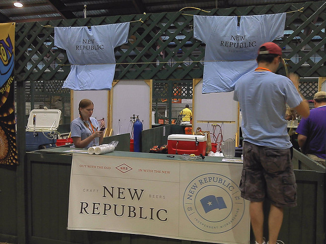 A booth at a festival. Adrienne is inside selling beer
